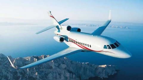 Private jet aircraft in flight over a coastal landscape