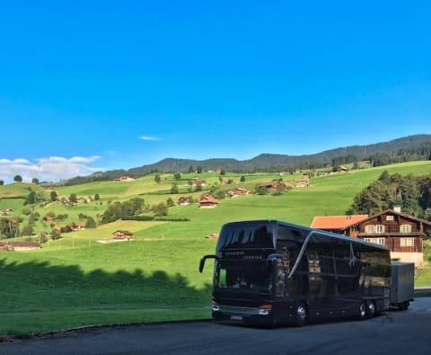 Absolute Touring France tour bus with trailer in Alpine countryside on European touring production