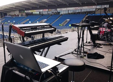 Keyboard and Hammond organ backline staged on open-air stadium stage during UK touring production soundcheck
