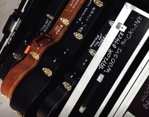 Woodys Backline Warsaw guitar cases and flight cases with Taylor and Fender inventory labels for touring production