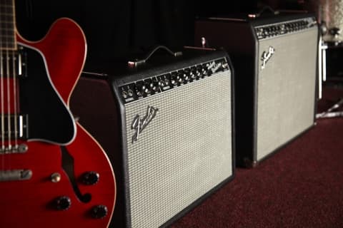 Fender guitar amplifiers and ES-335 style guitar staged for backline hire in the UK