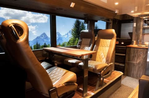 Great Dane Coach ApS luxury tour bus lounge with leather seats mountain views and wood trim interior